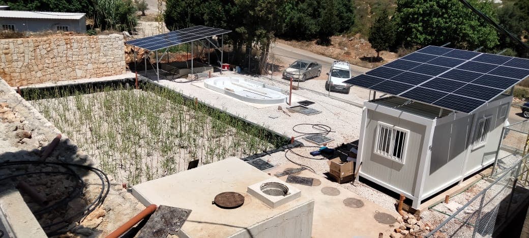 The Saida wetland project site with reed beds, solar panels and a site container